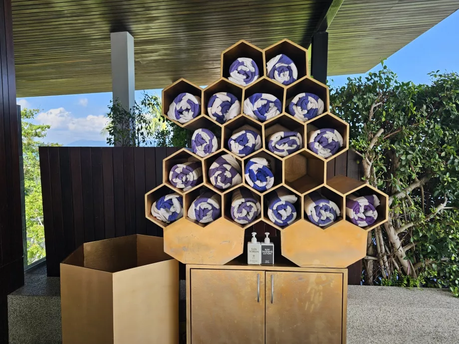 Törölköző és naptej a medencénél